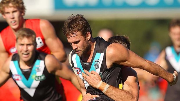 Port Adelaide's Jacob Surjan is stifled by Jeremy Taylor of the Suns, but it wasn't enough to prevent a seven-goal thrashing.