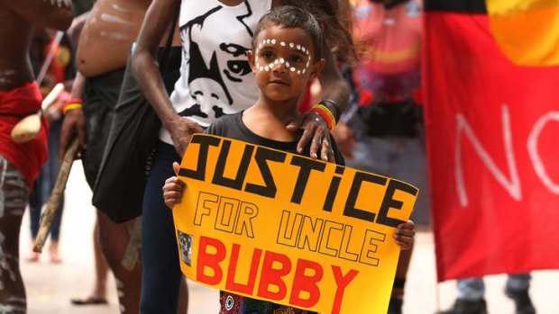 Justice Kirk, five, holds a sign about his uncle Clinton Speedy-Duroux, who was killed aged 16 in 1991.
