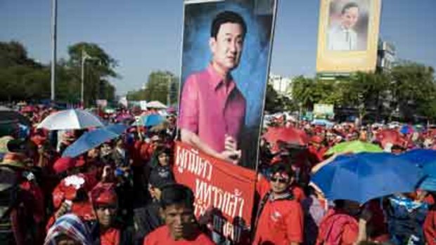 Red-shirted supporters of deposed Thai premier Thaksin Shinawatra hold placards with his porptrait and shout slogans as they join a mass rally in downtown Bangkok.