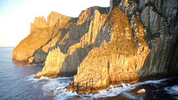 Wet and wild ... the cruise boat passes the soaring cliffs of Tasman Island.