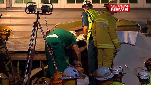 Paramedics and firefighters work to free the injured driver.
