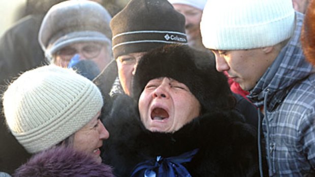 The mother of a Russian nightclub fire victim cries during her daughter's funeral outside Perm on December 7.