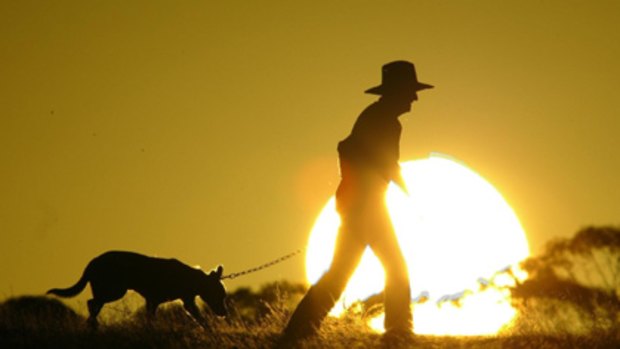 A farmer takes advantage of daylight saving to take his dog for a walk.