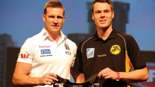 Collingwood coach Nathan Buckley presents Matthew Scharenberg with the Collingwood guernsey during the 2013 draft on November 21, 2013, on the Gold Coast.