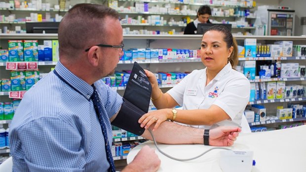 Pharmacist Catherine Bronger takes the blood pressure of a customer.