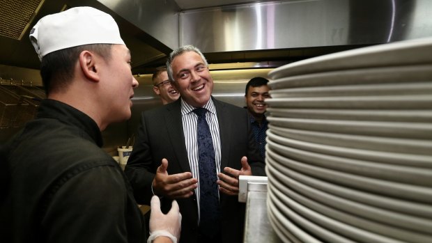 Treasurer Joe Hockey talks to kitchen staff during a visit to a cafe in Queanbeyan on Thursday.
