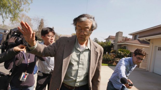 Satoshi Nakamoto is surrounded by reporters as he leaves his home in Temple City, California.