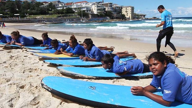 School's out: Aboriginal children learn to ride the surf at Bondi.
