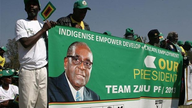 Zanu-PF activists hold a banner featuring the 33-year-old picture of Robert Mugabe