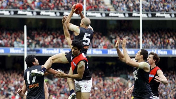 Blue heaven: Chris Judd reaches for the sky, courtesy of Bomber Paddy Ryder.