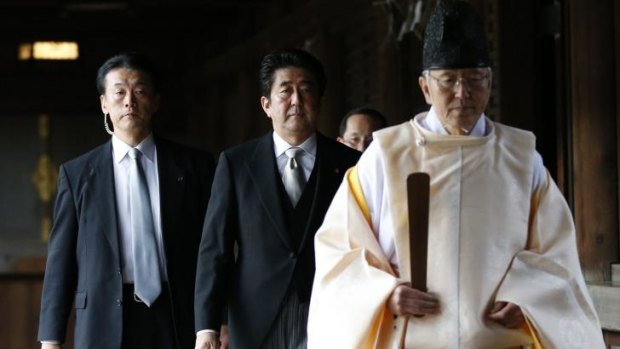 Courting controversy: Japan's Prime Minister Shinzo Abe, centre,  led by a Shinto priest, visits the  Yasukuni shrine in Tokyo on December 26.  The move is likely to anger Asian neighbours China and South Korea.