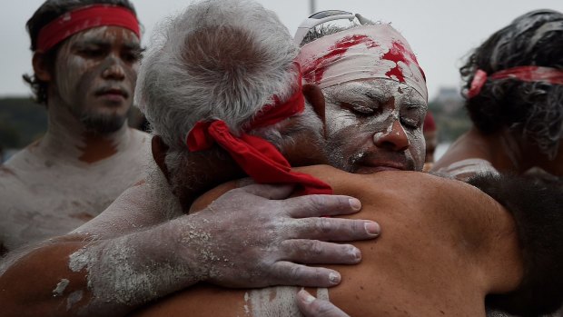 Members of the Koomurri Aboriginal Dance Troup embrace.