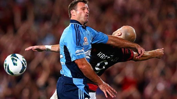 Excuse me mate: Sydney FC's Lucas Neill gets handsy mid-air with Wanderers counterpart Dino Kresinger.