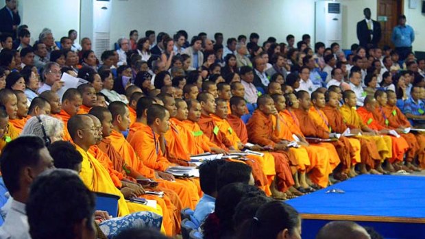 Buddhist monks and other Cambodians crowd the courtroom in Phnom Penh for the trial of three top Khmer Rouge leaders.