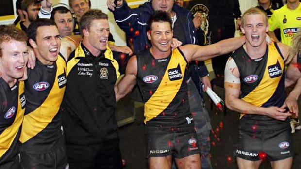 A thrilled group of Richmond players - and coach Damian Hardwick - sing the team song after their last-gasp victory over Sydney on Sunday. Ben Cousins is second from right.