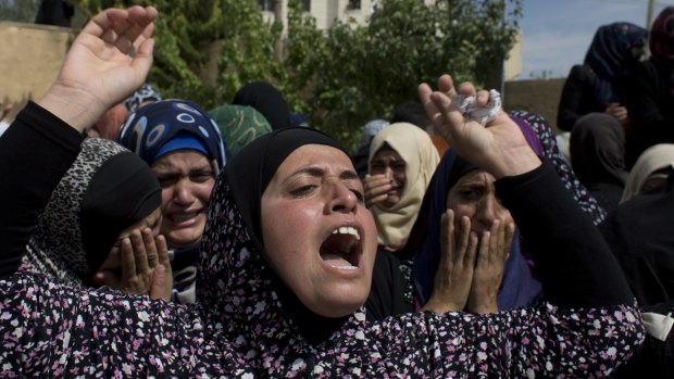 Palestinian mourners cry at the family house upon the arrival of the body of Amjad Jundi, 19, who was killed after stabbing a soldier on a bus in southern Israel.