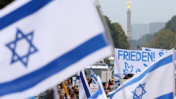 Israeli flags and a German banner reading "peace" fly in Berlin during Sunday's rally. 