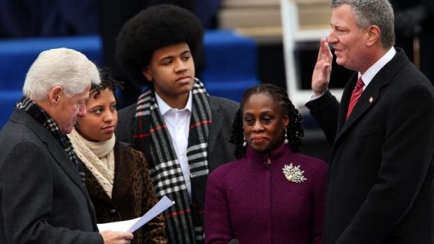 New York City's new mayor, Bill de Blasio (right), is sworn in by former President Bill Clinton (left) as his family watches.