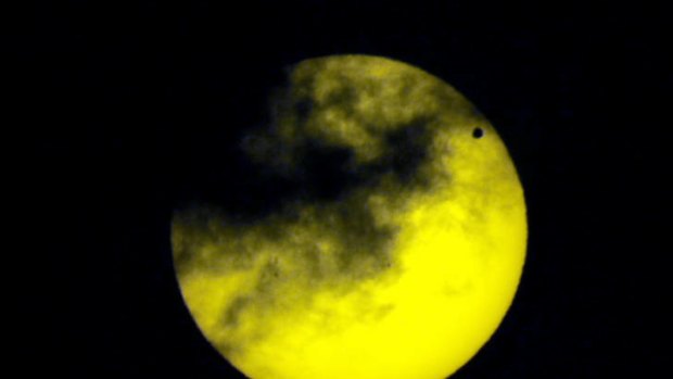 Venus, upper right, transits the sun as seen through a dark glass from Quito, Ecuador.