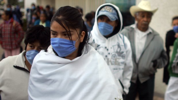 People wearing protective face masks stand outside a hospital in Toluca, Mexico.