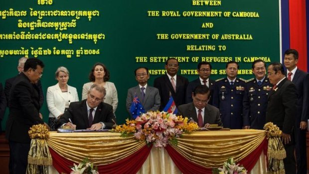 Immigration Minister Scott Morrison and Cambodian Interior Minister Sar Kheng sign the agreement. 