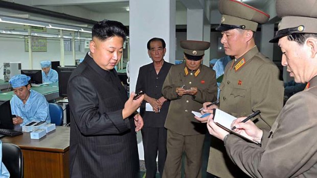 North Korean leader Kim Jong-Un inspects the Arirang smartphone.