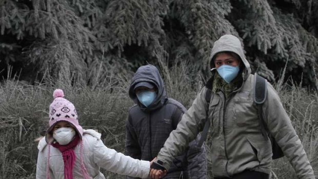 Ash cloud ... locals in Chile's Neuquen village protect themselves from ash particles as the effect continues to be felt worldwide.