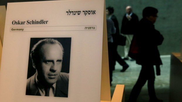 Visitors walk past a portrait of Oskar Schindler at the Yad Vashem Holocaust memorial museum in Jerusalem last week.