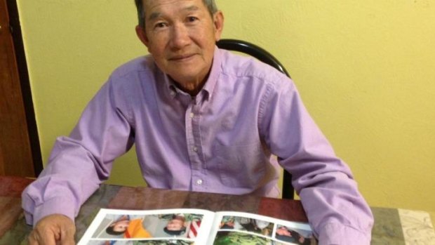 At home in Albuquerque, Bao Tran looks at a photo album Kimberly Mitchell made for him and his family (Anh Do / Los Angeles Times)