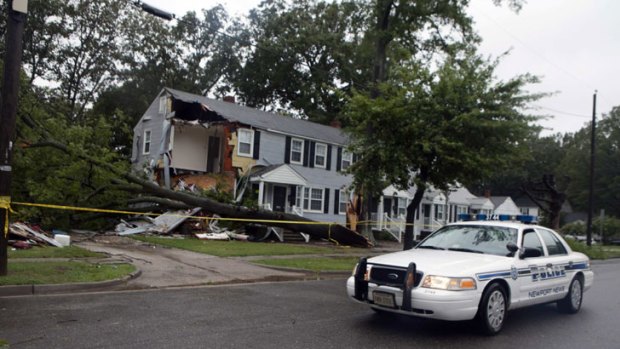 A police car passes the wreckage of an apartment block in Newport News, Virginia, where an 11-year-old boy died when a tree fell on the building.