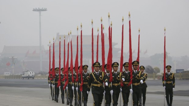 An honour guard in Tiananmen Square in Beijing last year, standing to attention as smog swirls in the background.