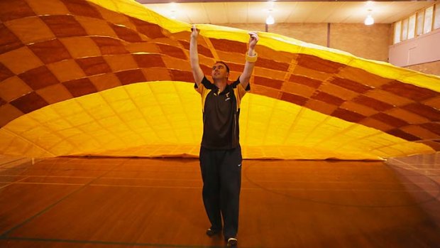 Members of the Hawthorn cheersquad prepare the Hawks grand final banner.
