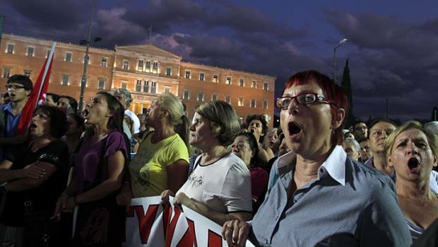 Protesters chant slogans in an anti-austerity protest in central Athens on Wednesday, after Greek government announced it will suspend more civil servants than originally planned and impose new pension cuts.