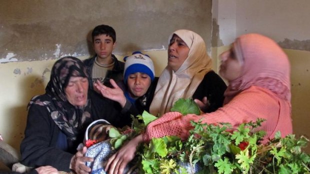 A family mourns over the body of one of five civilians killed during a Syrian army bombardment of al-Qusayr in Syria's Homs province this week.