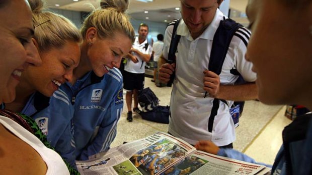 Read all about it &#8230; Kyah Simon and her Sydney FC teammates pore over our coverage in Monday's Herald.