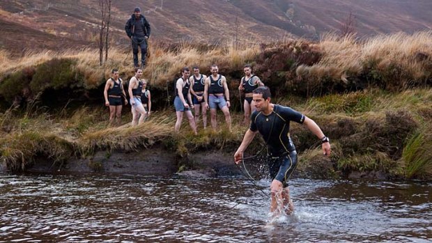 Bear Grylls teaches students how to safely cross a river at the Survival Academy.