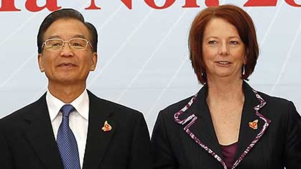 Julia Gillard with China's Premier Wen Jiabao wait for other leaders at the ASEAN summit in Hanoi on Saturday.