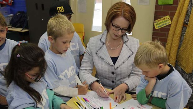 Julia Gillard helps children from Gold Creek Primary draw a fire-breathing dragon last week.