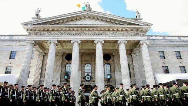 Irish soldiers march past the General Post Office in Dublin.