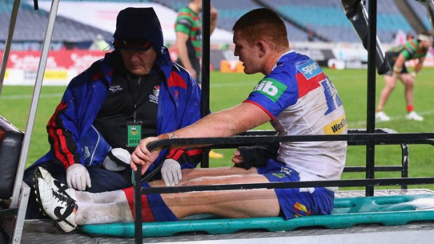 Alex McKinnon of the Knights is taken from the field on Saturday.