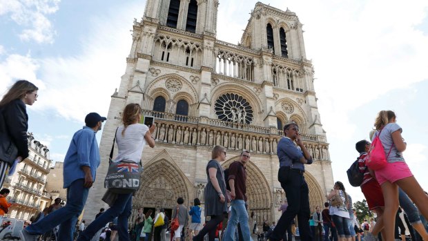 People stand in line outside Notre Dame Cathedral in Paris. France is the world's number one destination.