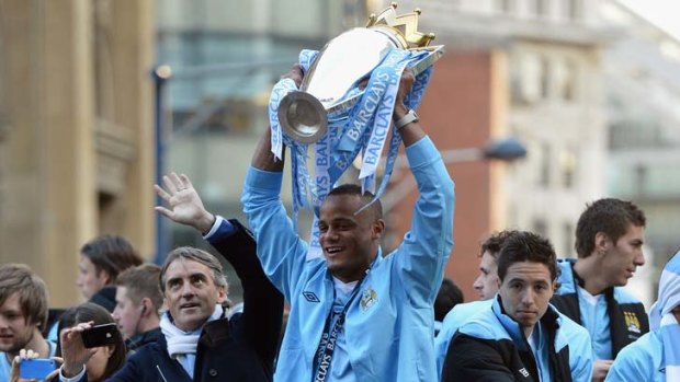 Jubilation: Manchester City captain Vincent Kompany (centre) and manager Roberto Mancini (left) celebrate with the team.