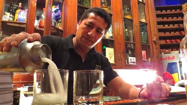 Salud: A barman pours a pisco sour.