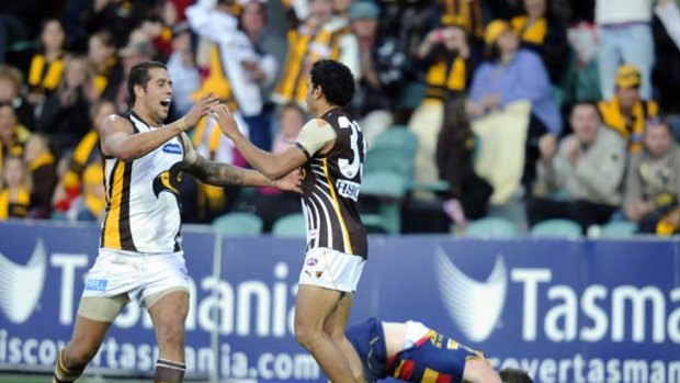 Hawthorn stars Lance Franklin (left) and Cyril Rioli celebrate yet another goal at  Launceston yesterday, while Adelaide players ponder a season lost.