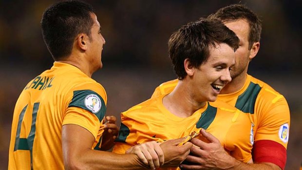 Well done: Robbie Kruse is congratulated by Socceroos veterans Tim Cahill and Lucas Neill.