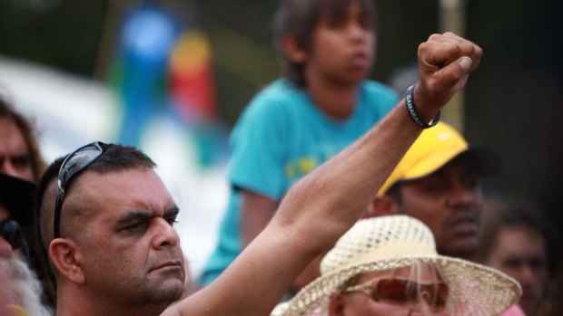 A man raises his hand as representatives  from the Aboriginal tent embassy deliver a statement to the media in Canberra today.