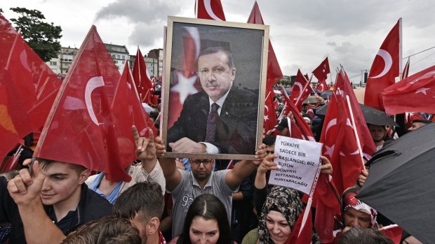 A protester holds a portrait of Tayyip Erdogan at a demonstration in Cologne, Germany.