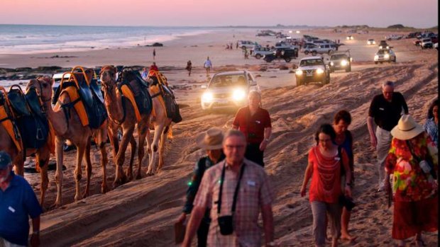 Over the hump: Camels, four-wheel-drives and tourists leave Broome's Cable Beach after watching the famous sunset.