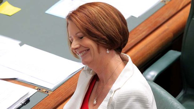 Prime Minister Julia Gillard smiles during question time at Parliament House today.