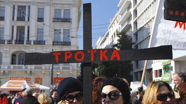 Frustrated &#8230; a demonstrator in Athens holds a black cross that reads ''Troika'', protesting the outside influences on the country.